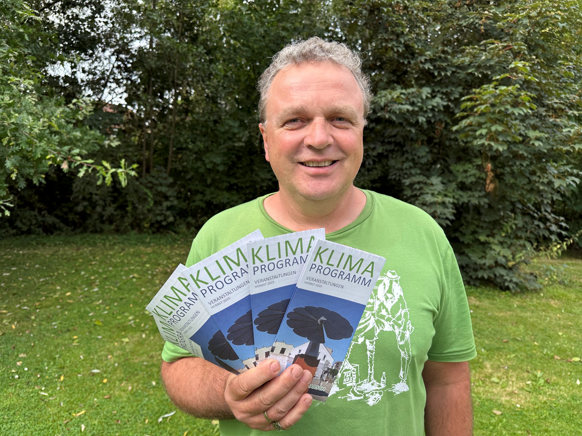 Klimaanpassungsmanager Sönke Hofmann freut sich auf das Klimaprogramm und präsentiert die Flyer.