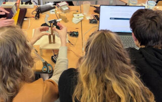 Schülerinnen und Schüler arbeiten an ihren digitalen Lösungen.