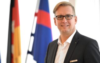 Landrat Stephan Siefken im Großen Sitzungssaal des Kreishauses in Brake vor den Flaggen der EU, Deutschlands und der Wesermarsch